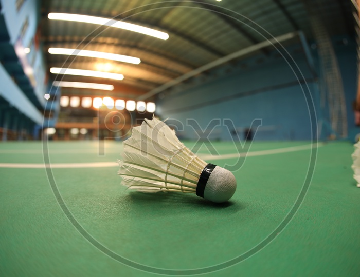 White badminton Shuttlecock on a green Shuttle Court Background