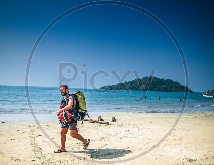 A person walking on beach with a backpack