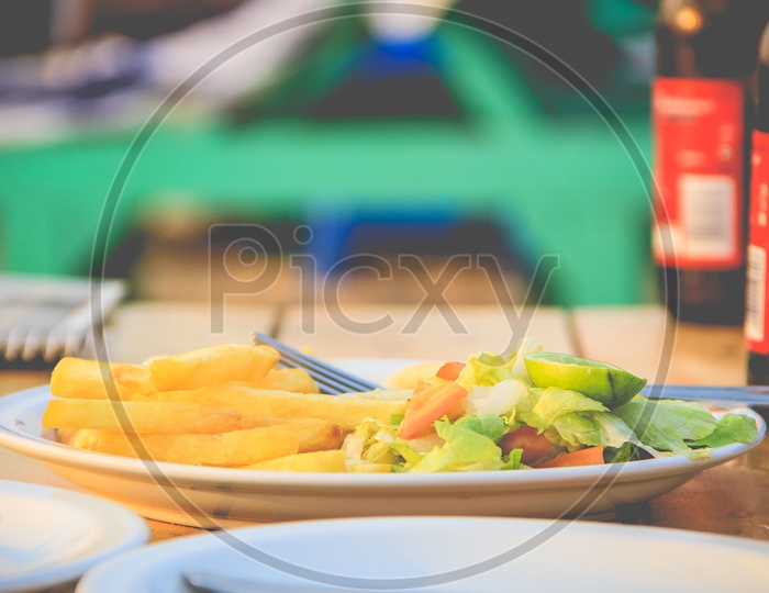 A plate with salad and french fries