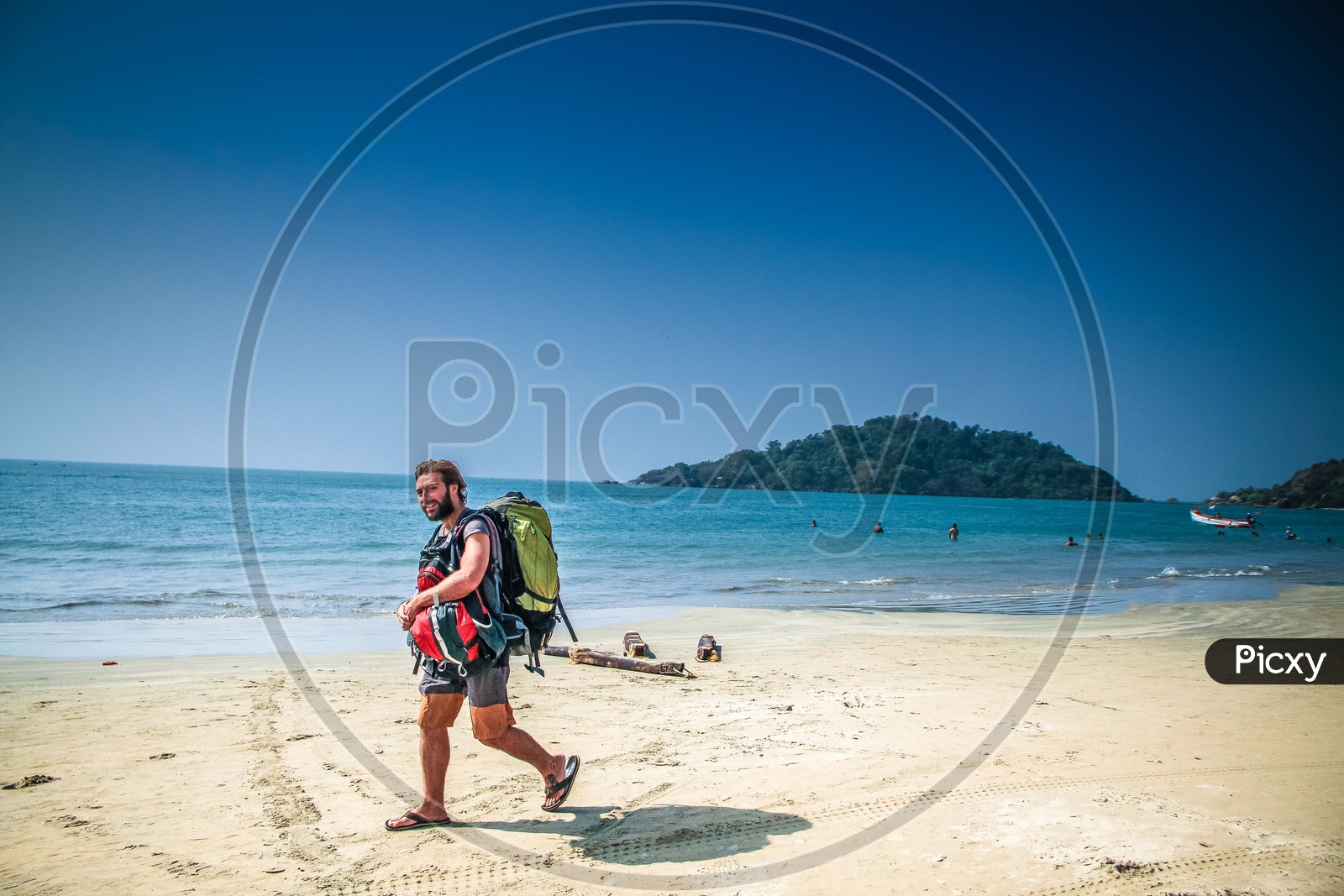 A person walking on beach with a backpack