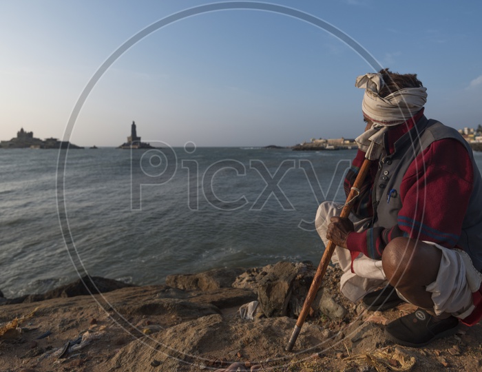 A man sitting at the sea shore