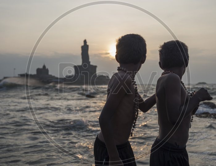 Two young boys in Sabarimala maala at the beach in Kanyakumari