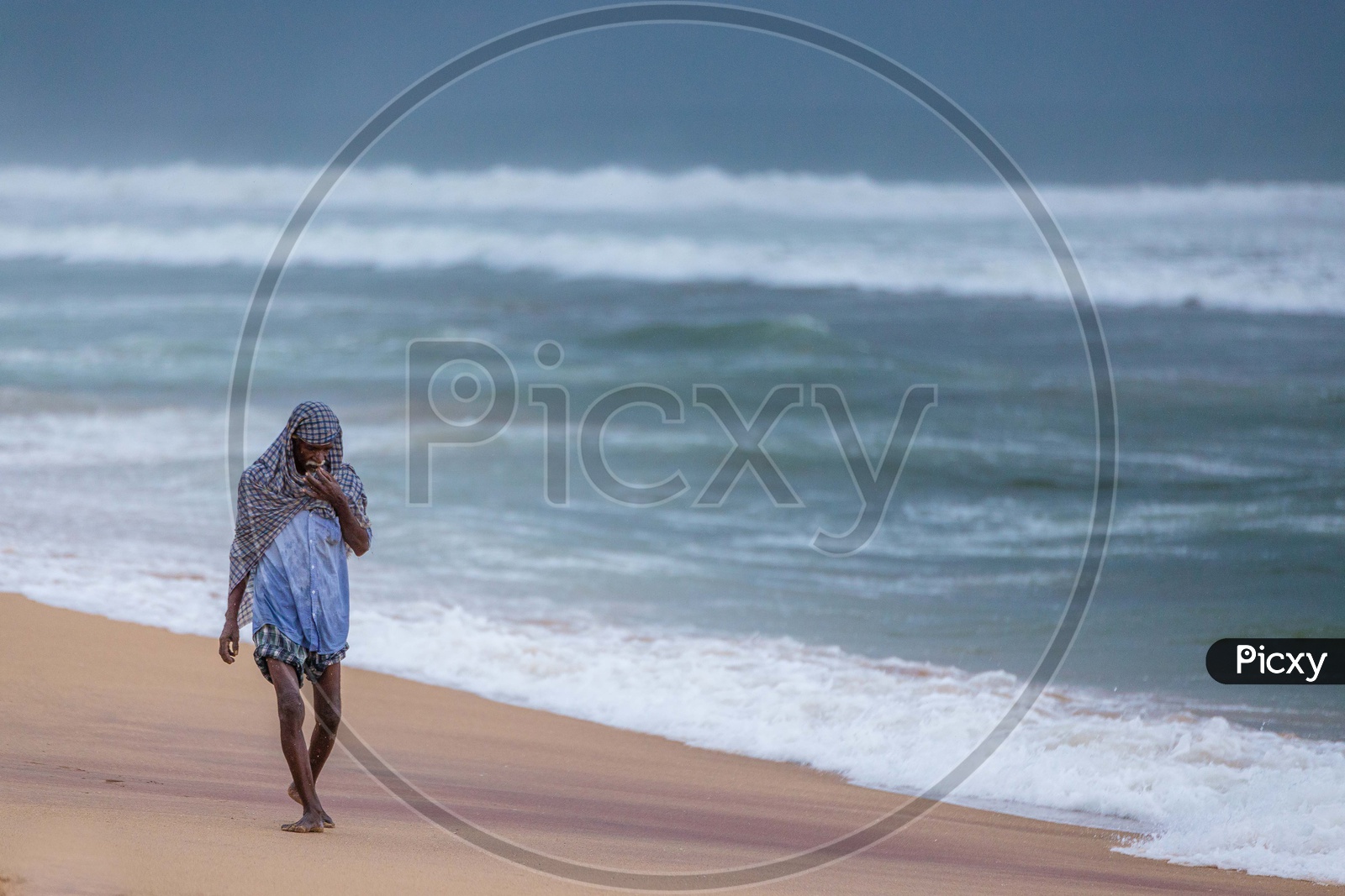 Man walking along the sea shore at Vizag beach