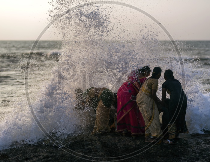 Women hit by high tide at the beach side