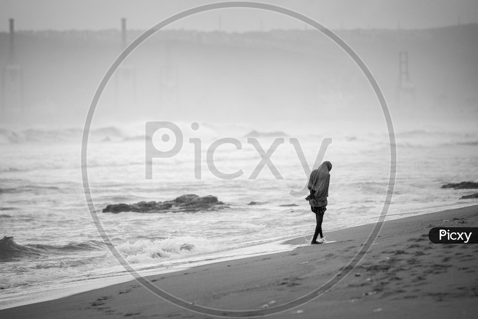 Silhouette of a man walking along the sea shore