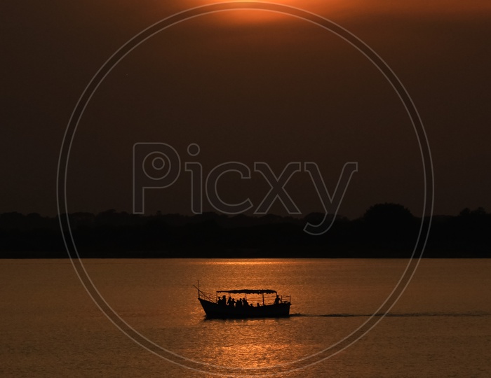 Man standing on a boat at Rajahmundry during sunrise