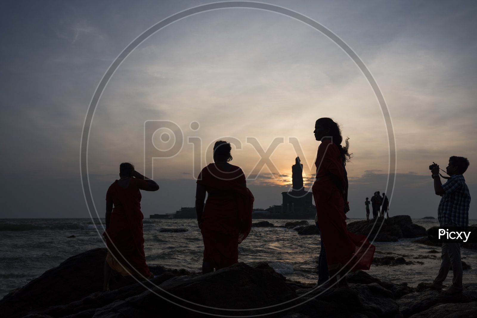 Silhouette of people standing by the beach at tiruvalluvar statue