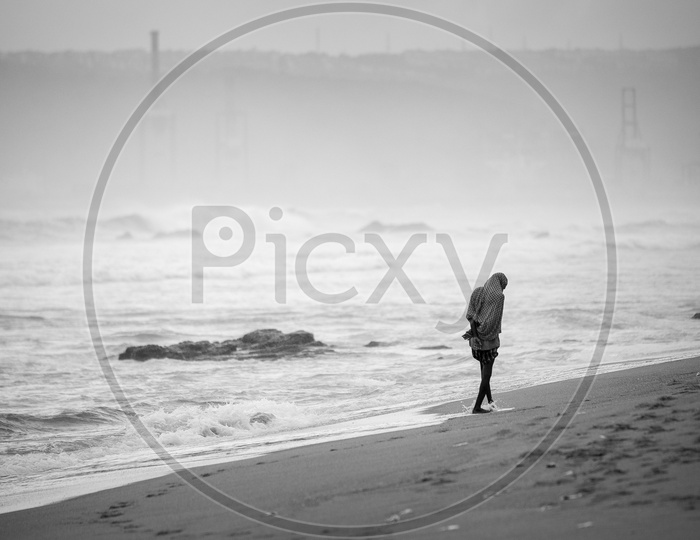 Silhouette of a man walking along the sea shore