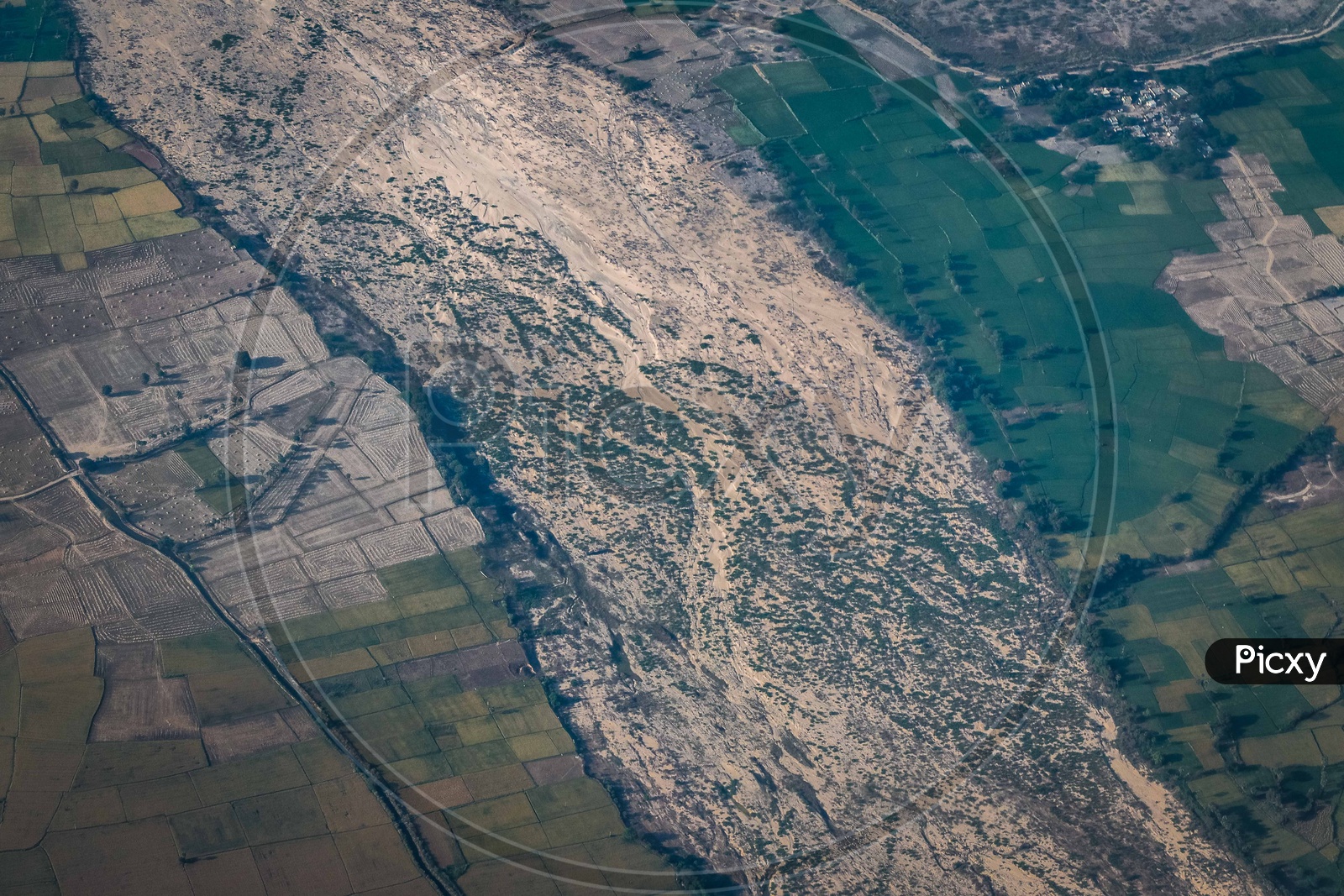 Aerial views of a dried up river and crops around