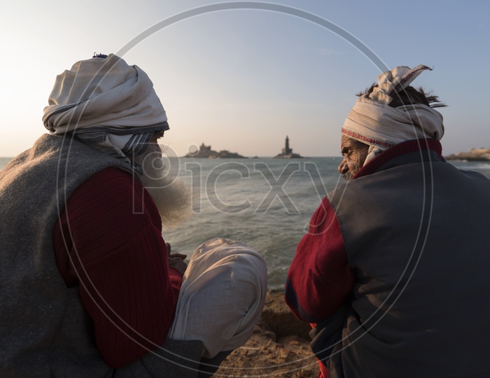 Two old men sitting at the sea shore