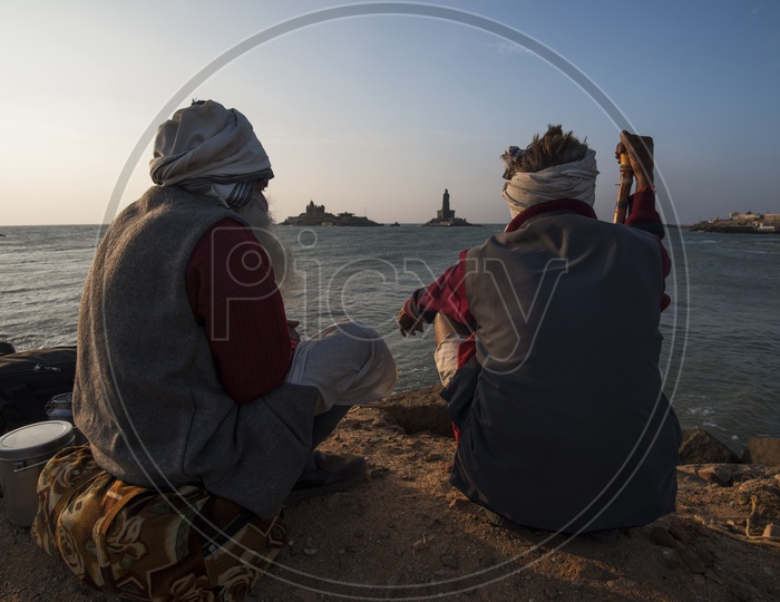 Two old men sitting at the sea shore
