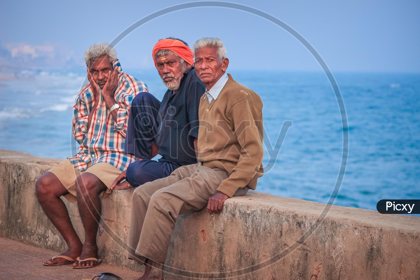 Image of Old men sitting at a beach-VV481552-Picxy