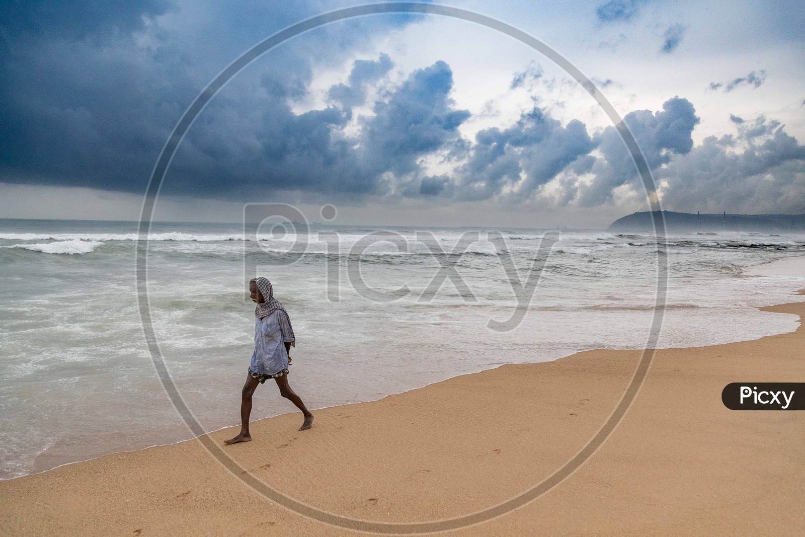 Man walking along the sea shore at Vizag beach