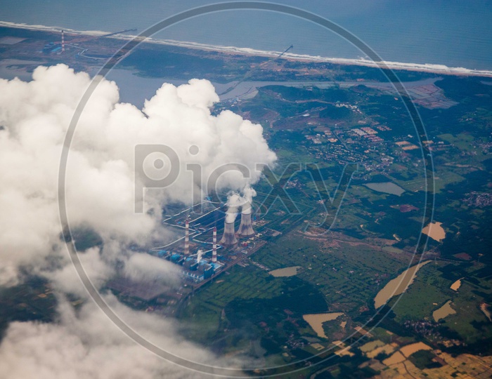 Aerial view of smoke coming out of turbines from a power plant