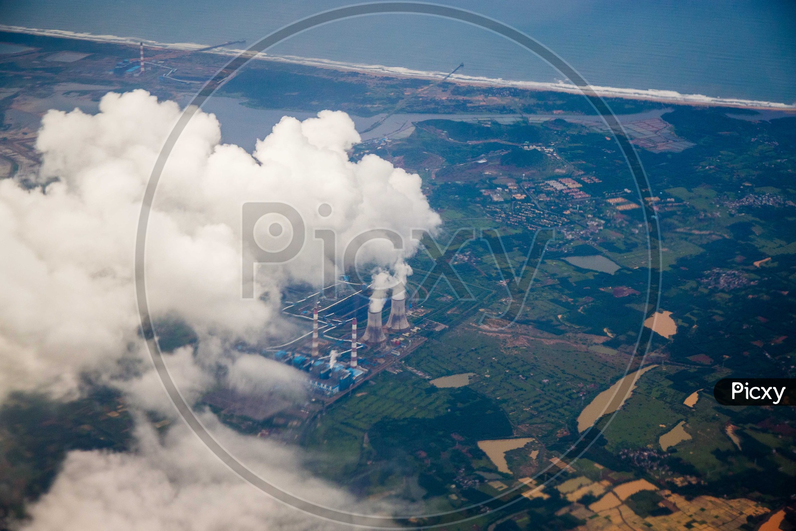 Aerial view of smoke coming out of turbines from a power plant