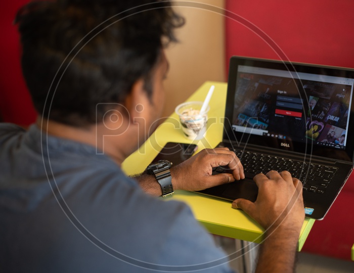 Indian Youth Entering Login Details of  Netflix on laptop