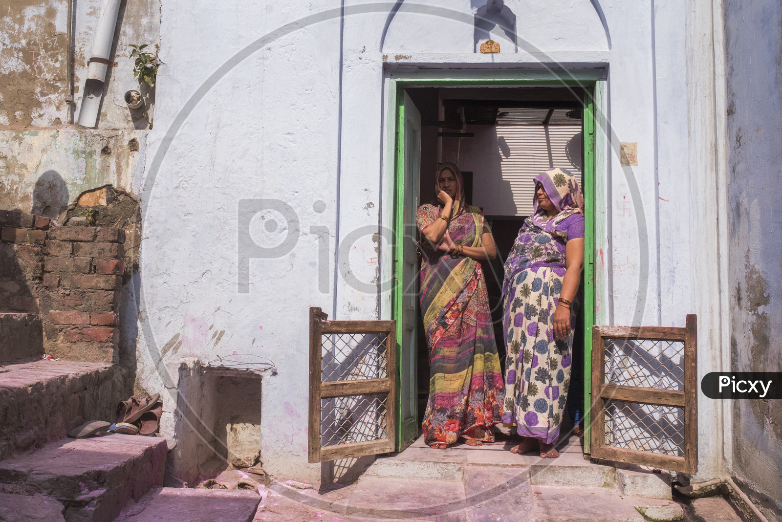 Women standing at the entrance of a house in mathura
