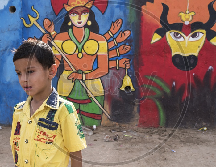 Indian Kid and Paintings on wall in background