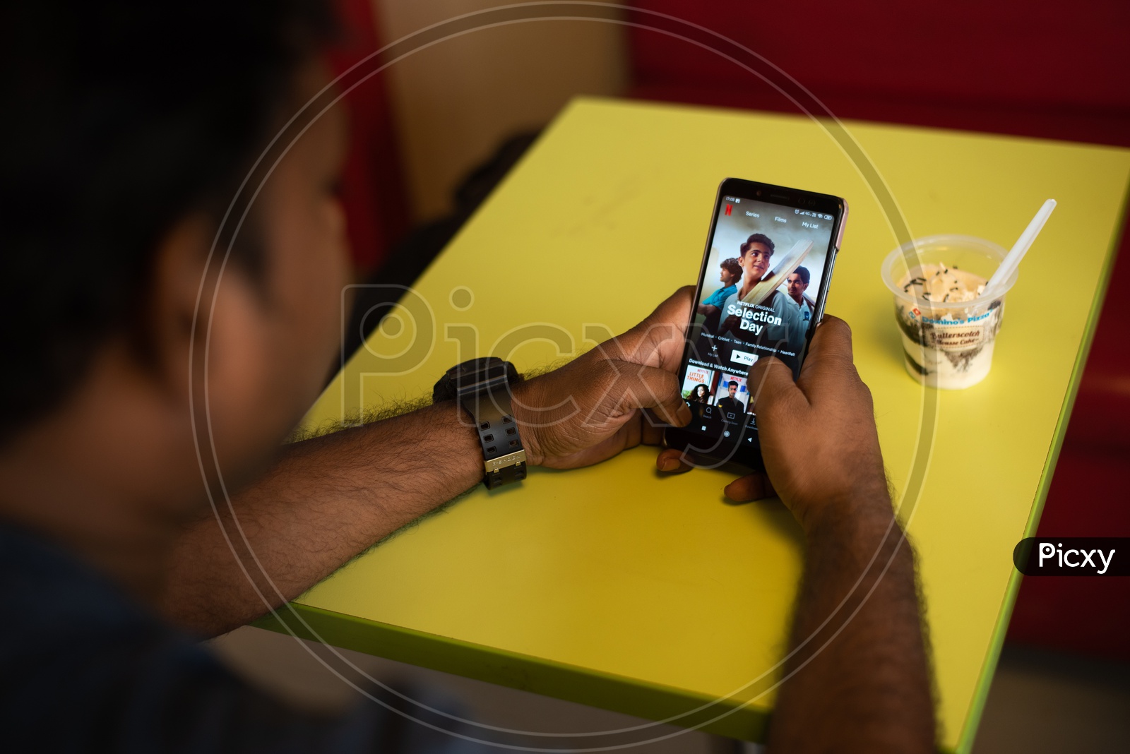 Indian youth Watching Netflix On Smart Phone