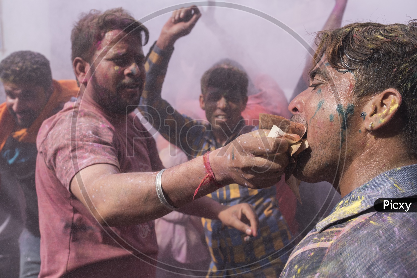 Man holding the money with his mouth during the Holi Festival