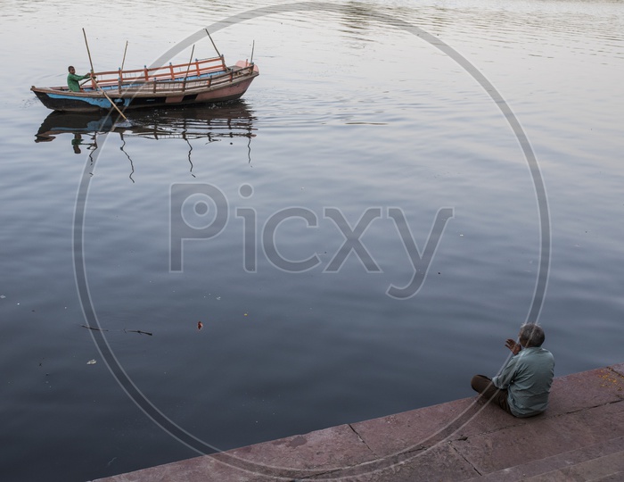 Old man sat on Ghat and Boat in river