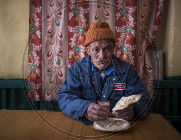 Kashmiri Old man Eating Paratha in a Hotel