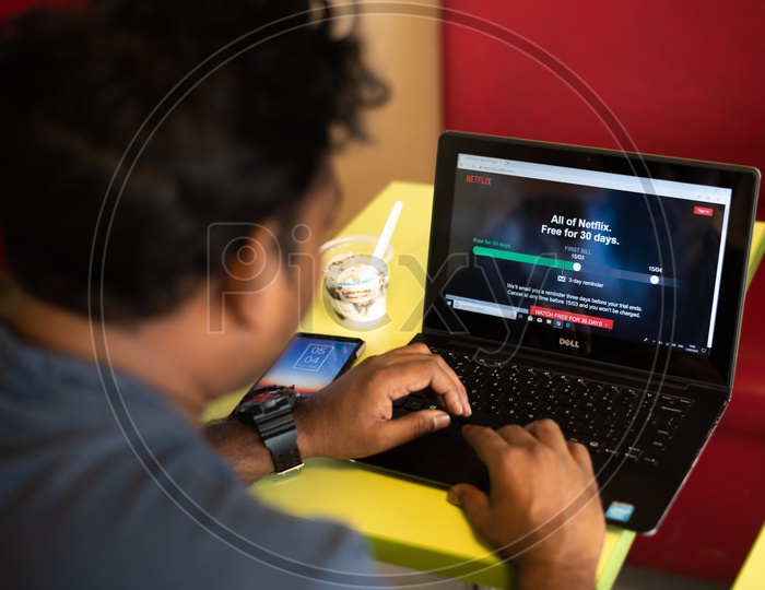 Indian Youth Using Netflix On Laptop