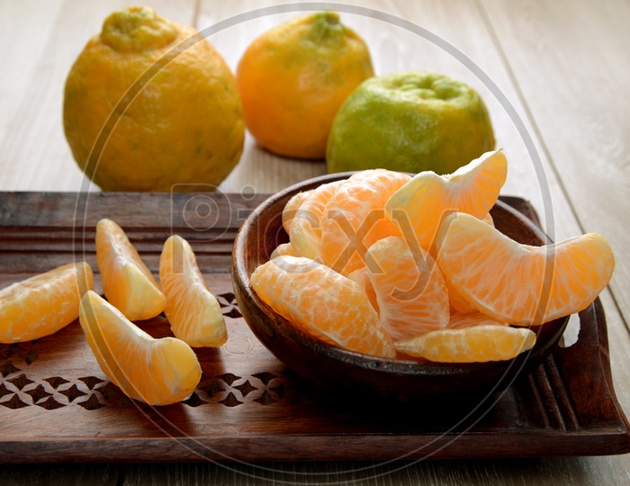Fresh Nagpur Oranges with slices in bowl on a table