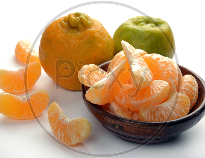 Fresh Nagpur Oranges with slices in bowl on a table