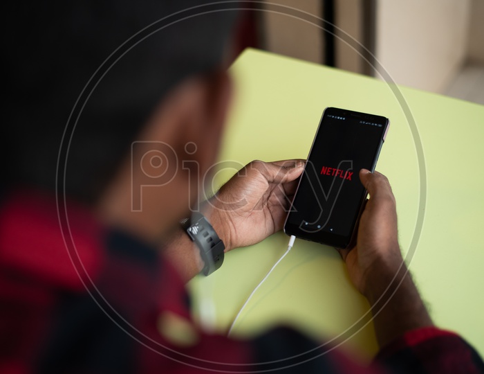 Indian Youth Using Netflix  on His Smart Phone