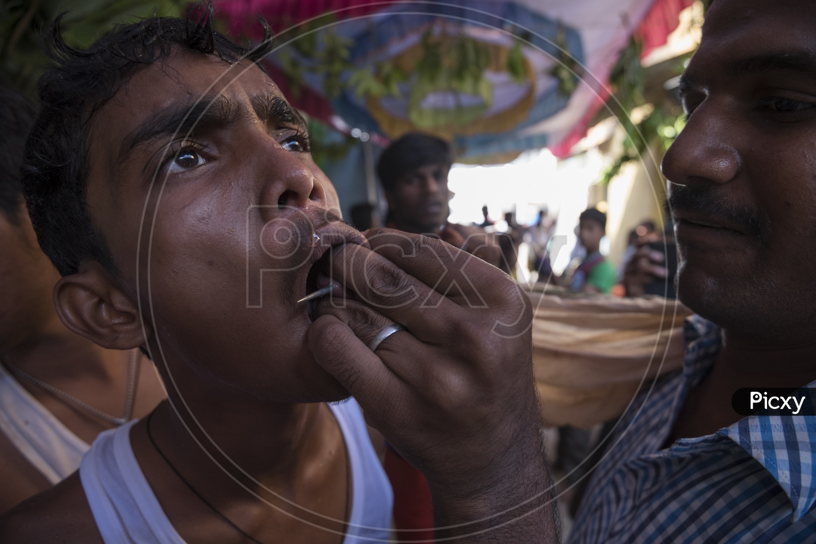A boy having needle in his mouth for Festival of Kali Kaveripattinam