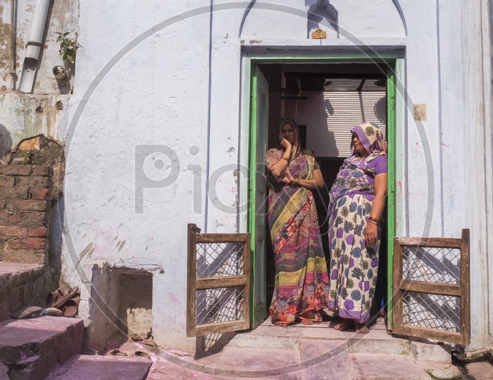Women standing at the entrance of a house in mathura