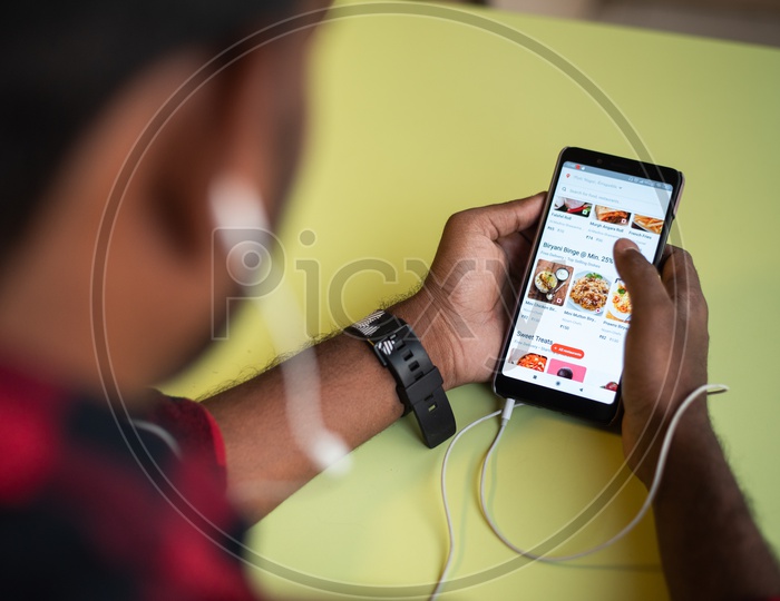 Indian youth ordering food online in Foodpanda, smart phone app