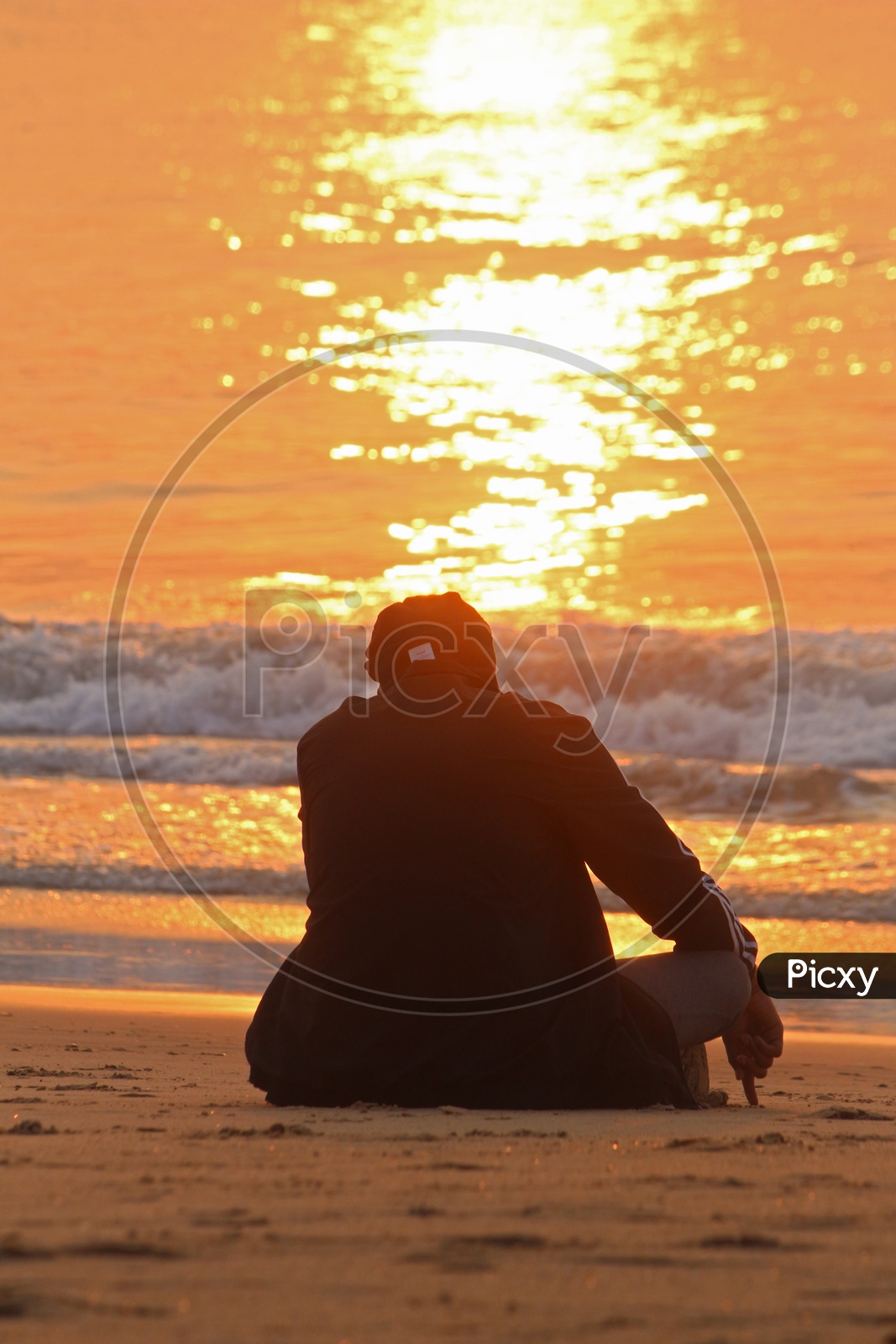 A person sitting alone and thinking at RK beach during the sunrise