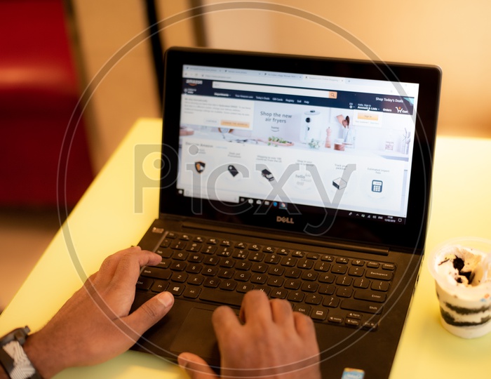 a man browsing Amazon, an e-commerce website on a Laptop PC