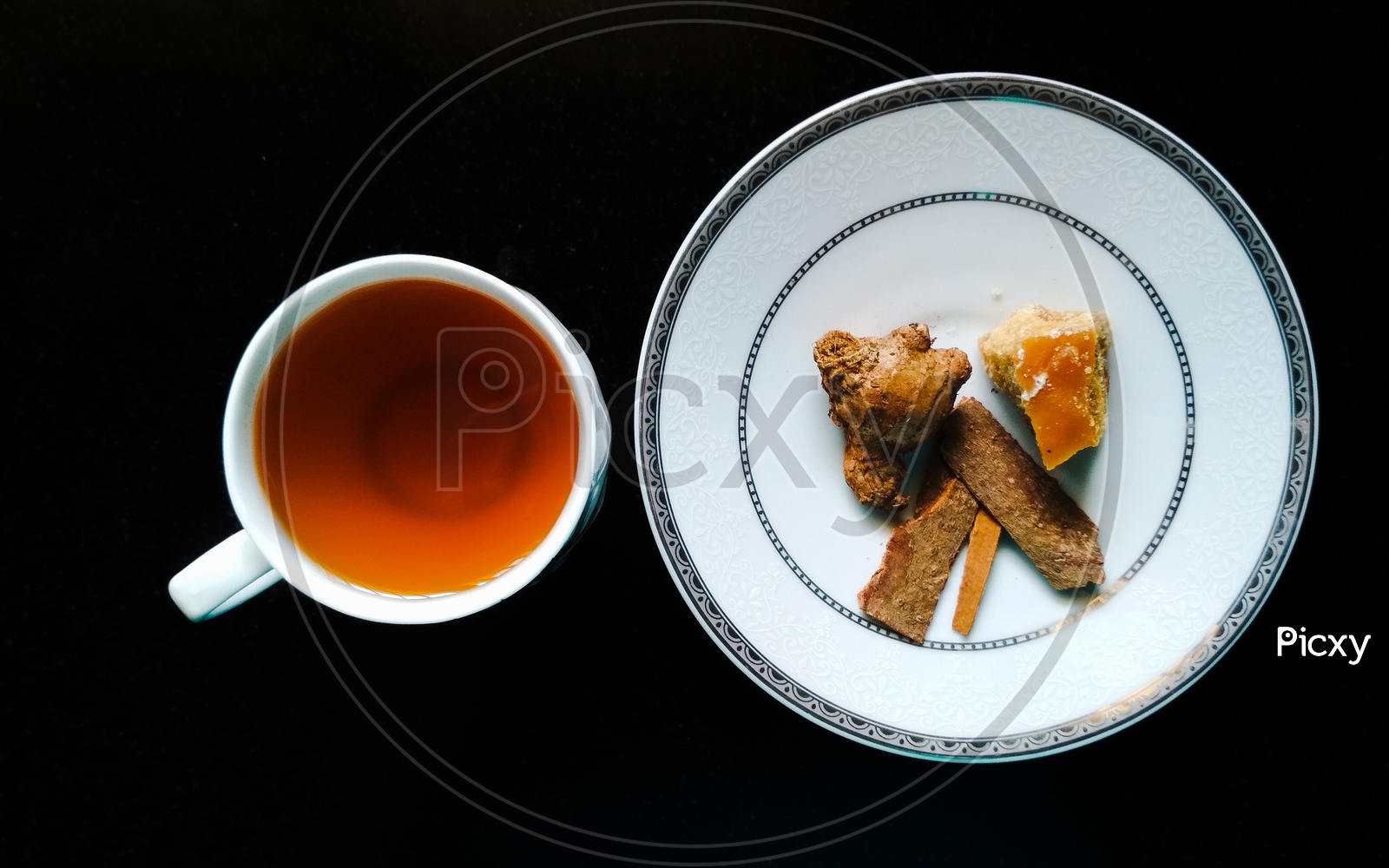 White ceramic tea cup with black tea - Cassia bark, ginger and jaggery