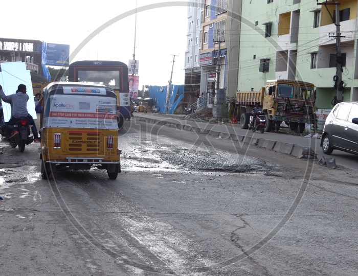 Broken roads and people commuting. Pot holes in Hyderabad