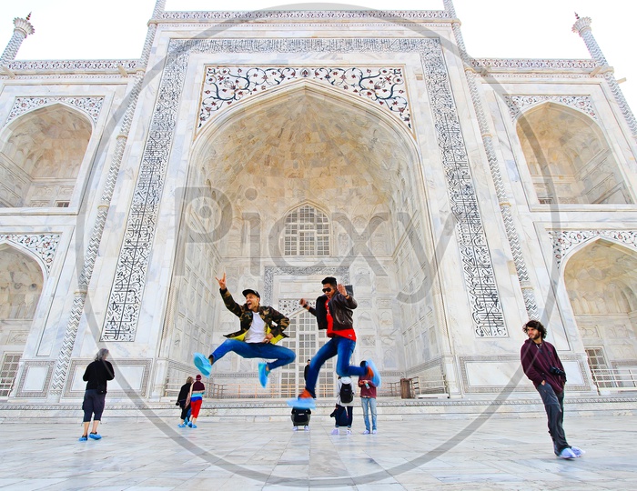 Men jumping in joy at Taj Mahal