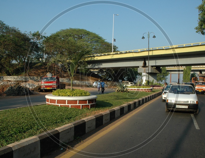 Moving traffic on a main road passing under the Mandovi bridge