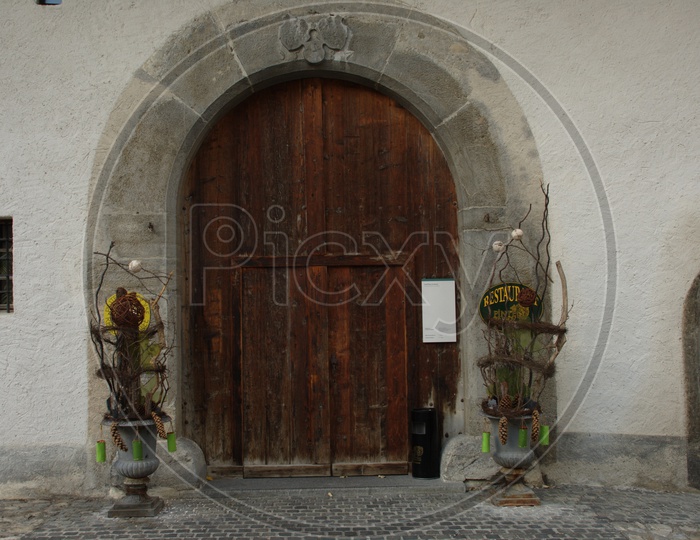 A arch like entrance of a building with large wooden doors