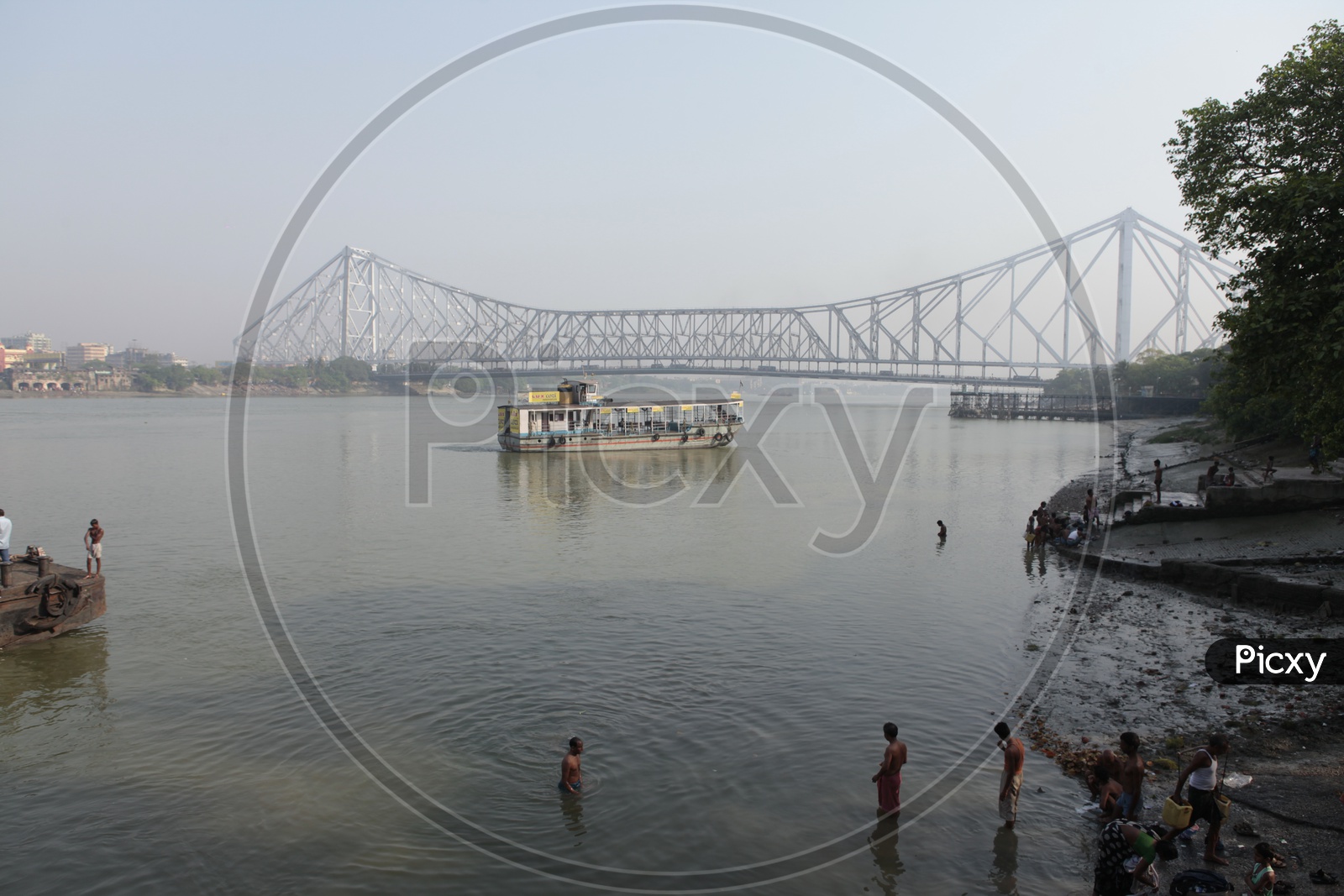 Local people taking bath in the Hooghly River alongside the Howrah Bridge