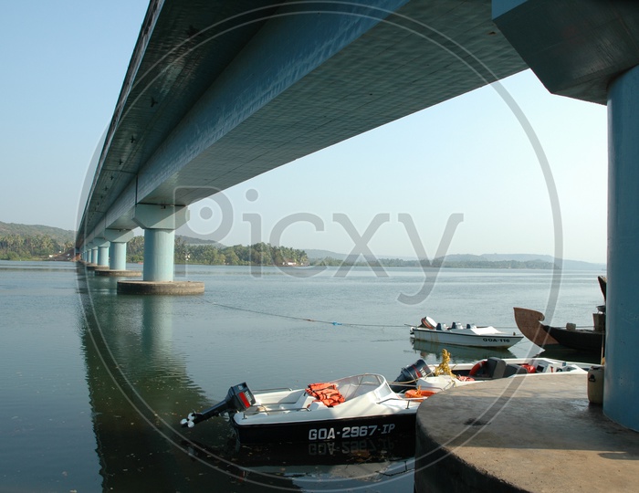 Boats in the Mandovi river under the Mandovi bridge