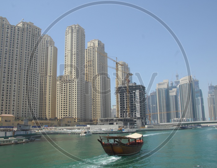 View of the city from the beach - Blue waters, tall buildings and a boat