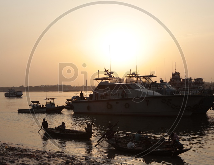 Boats alongside the Hooghly River during the sunset