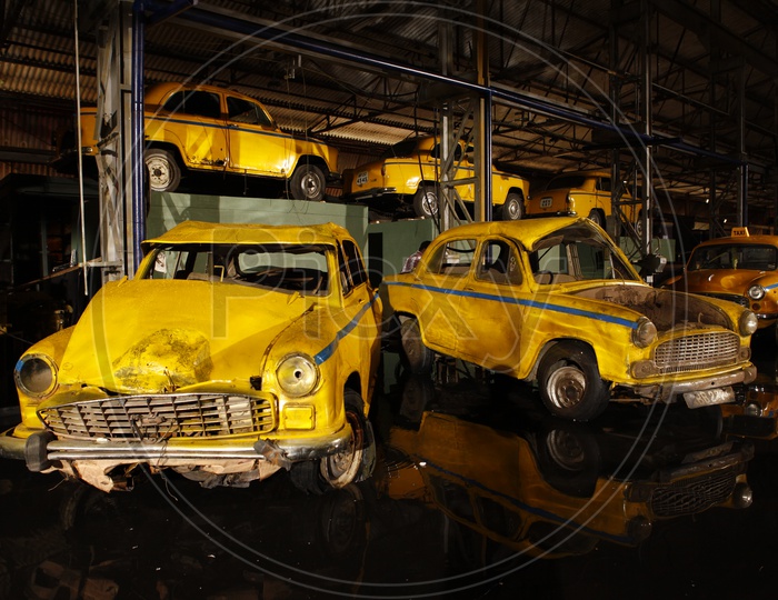 Wrecked Yellow  Coloured Taxi Cars In a Shed
