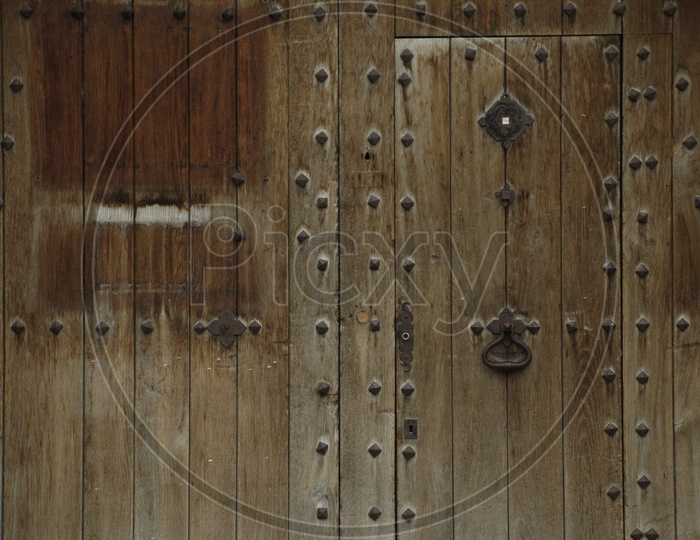 A large wooden door with large bolts