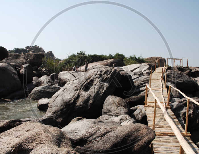 Log footbridge on the rocks over the river