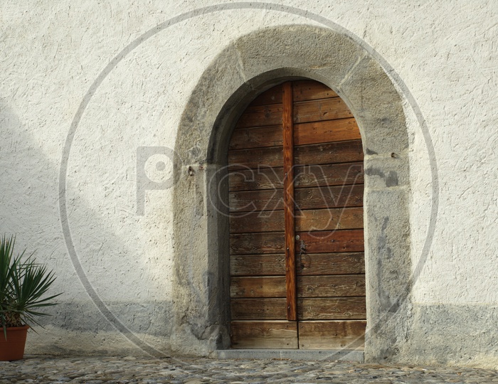 A arch like entrance of a building with wooden doors