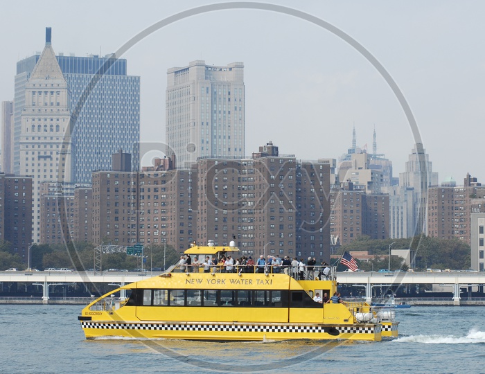 New York Water Taxi on the sea alongside the contemporary buildings
