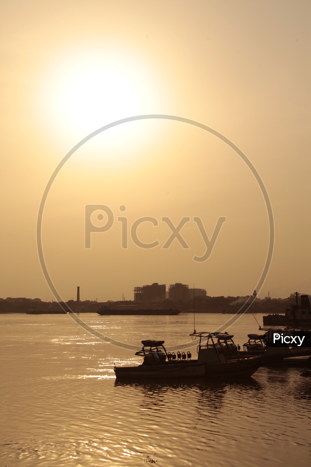 Boats alongside the Hooghly River during the sunset